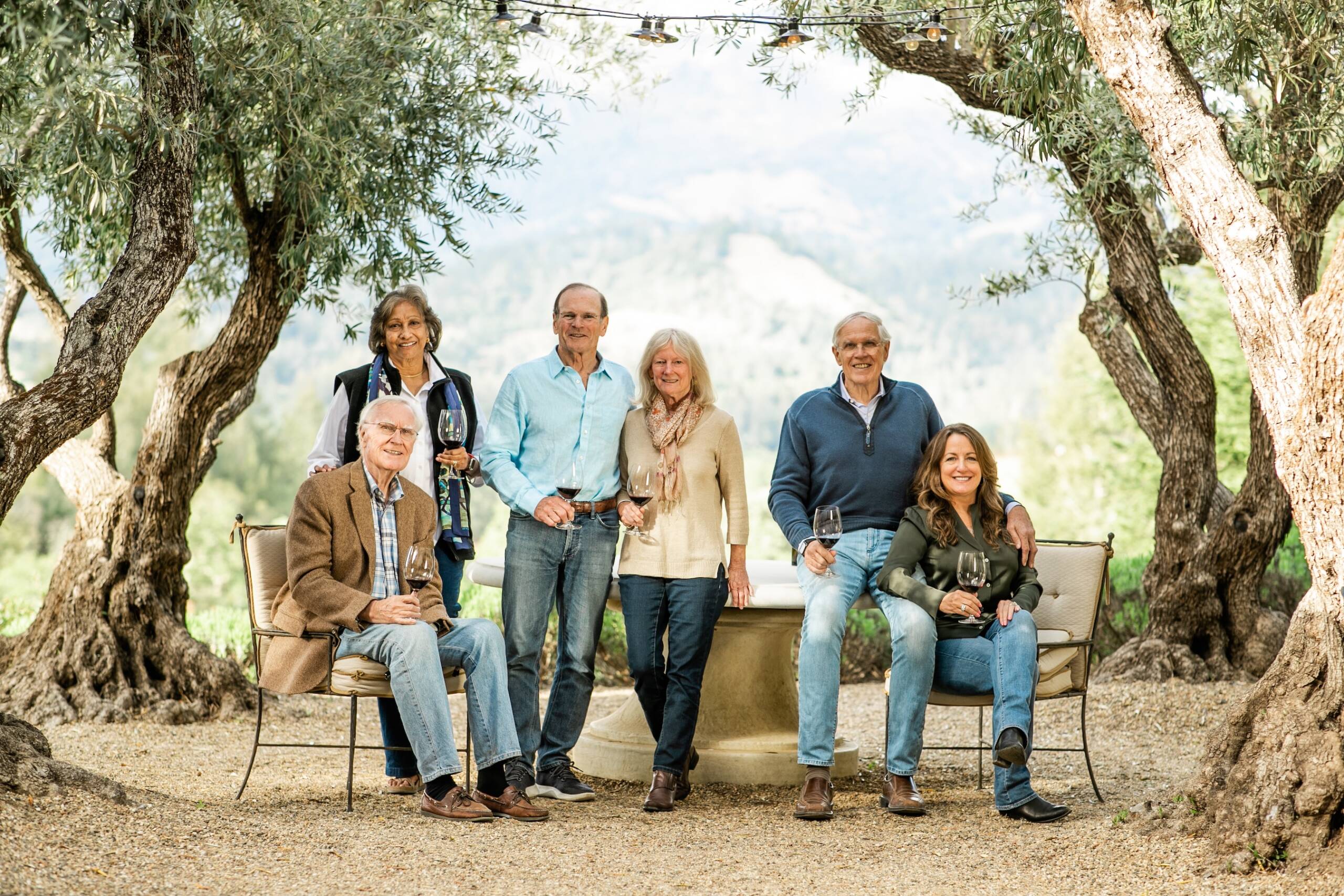 Essel & Menakka Bailey, Tom & Cindy Costin, Jim & Kelley Bailey seated outside on adirondack chairs