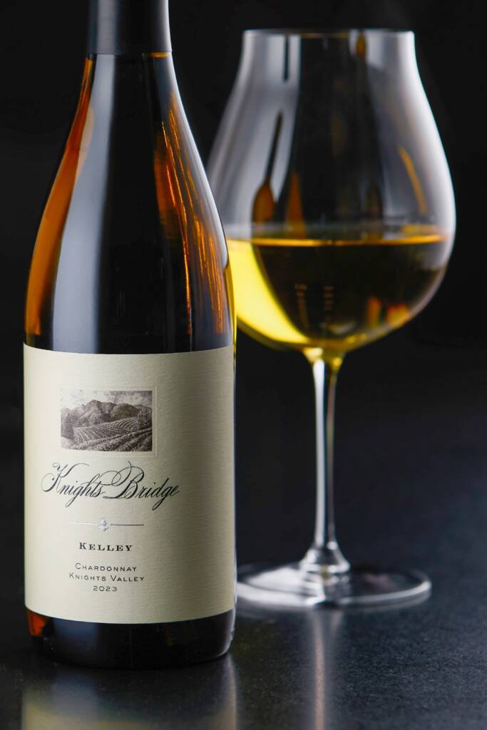 Kelley bottle with large bulbous class with golden Chardonnay in it.
