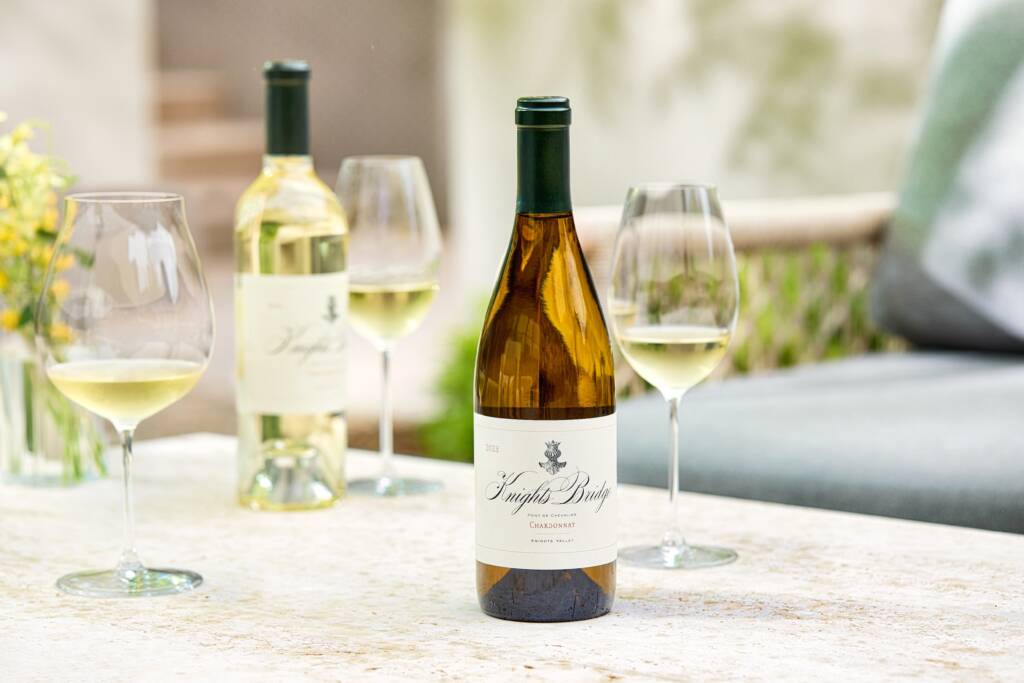 Chardonnay & Sauv Blanc on sunlit outdoor table with white cloth.