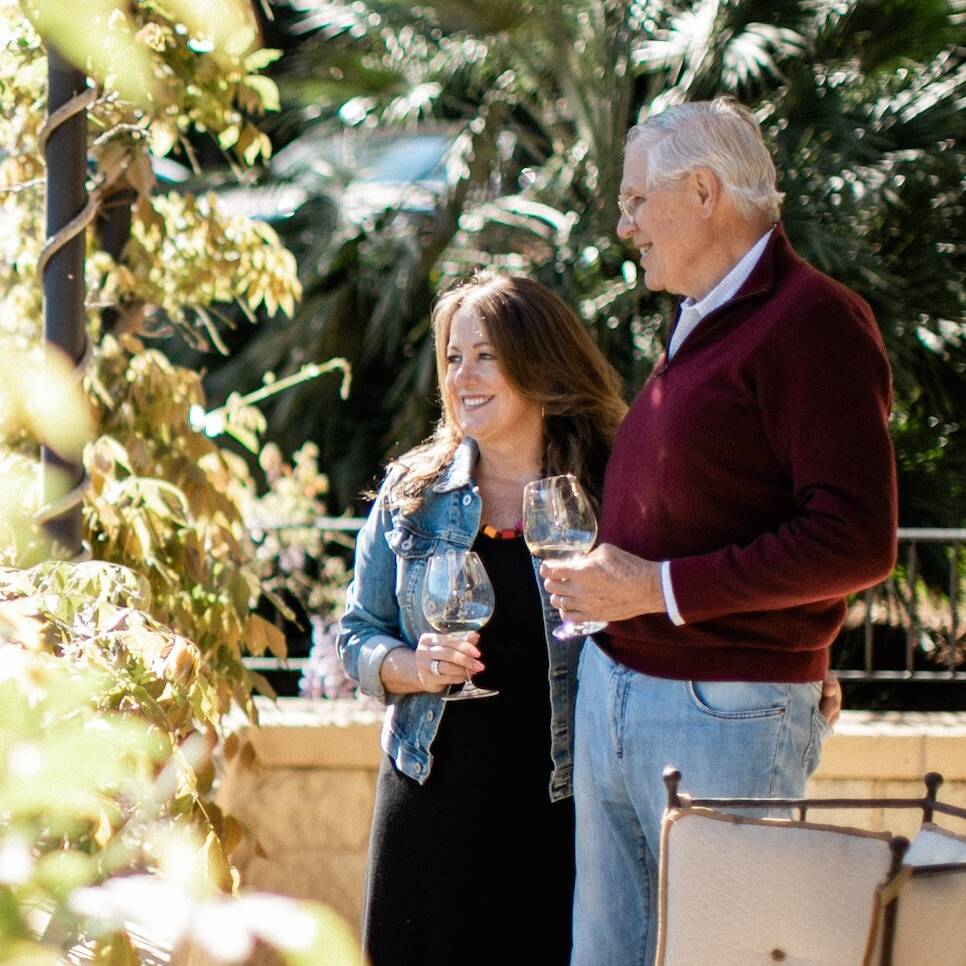 Kelley & Jim Bailey looking out past wisteria vines
