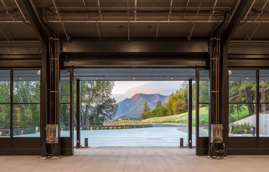View of the mountains through the production area's sliding glass garage doors, at Knights Bridge Winery.
