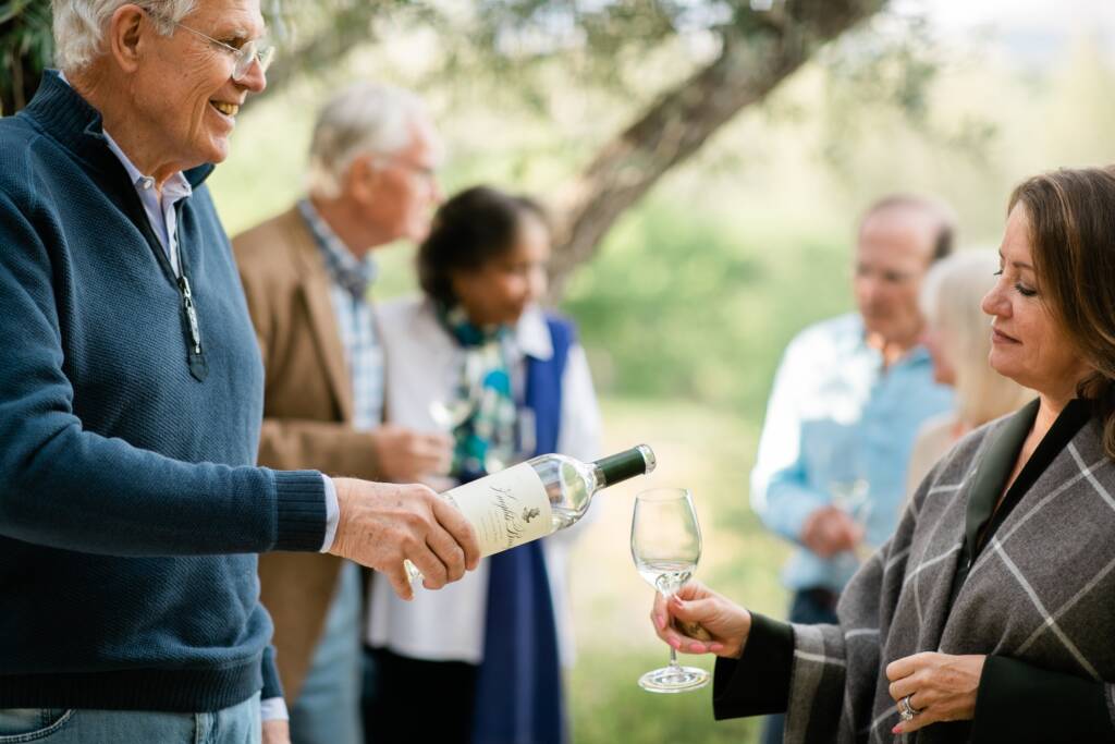 Jim pouring wine for Kelley at event